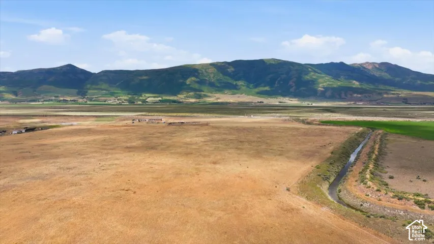 Expansive open land with a visible irrigation canal and distant mountains