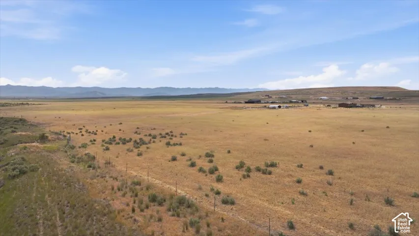Expansive open land with varied natural vegetation and distant mountain ranges