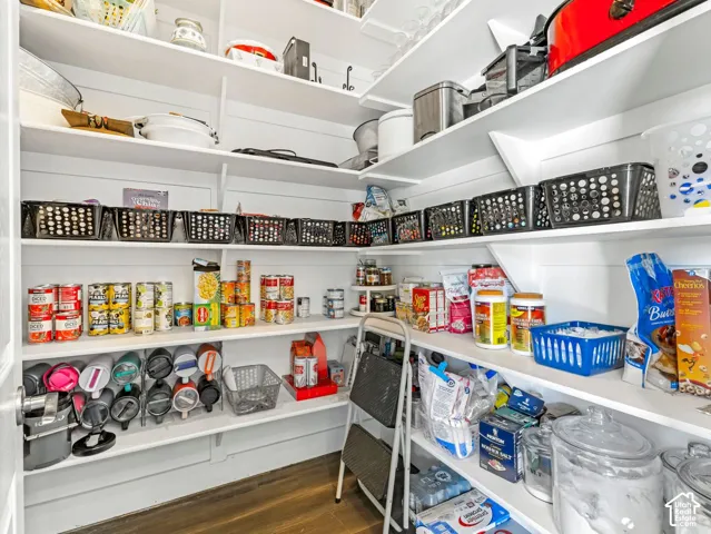 Extensive pantry with multiple white built-in shelves and shiplap-style wall paneling