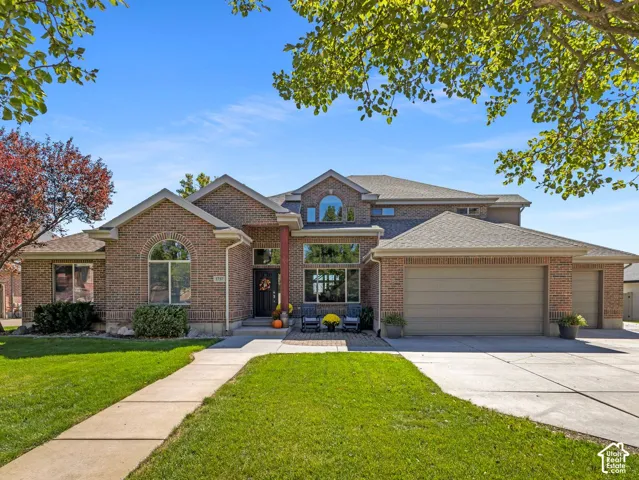 Brick exterior with multiple gables, arched window, and a concrete driveway