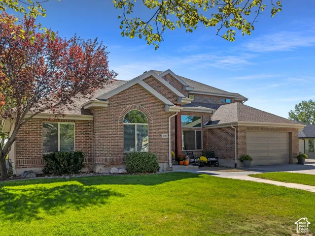 Brick exterior with gabled roof lines, an arched window, and an attached garage