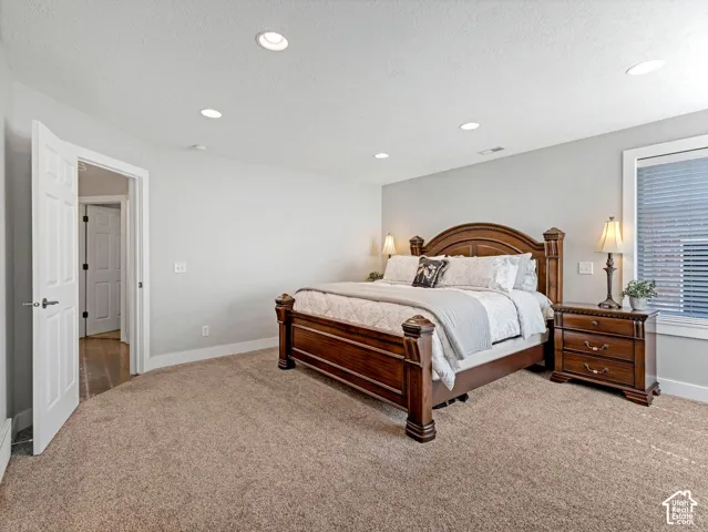 Recessed ceiling lighting, textured carpeting, white trim, and a window with blinds
