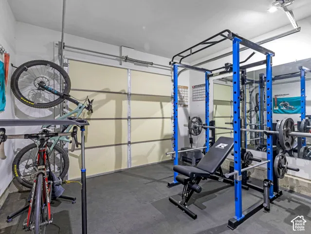 Garage space with overhead lighting, wall-mounted storage, and rubber flooring