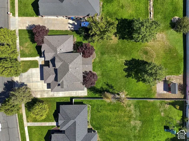 Spacious lot featuring a multi-gabled roofline, concrete driveway, and established landscaping