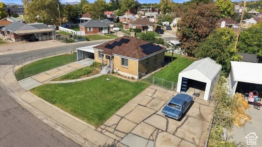 Brick exterior with solar panels, a brown shingle roof, and a detached garage
