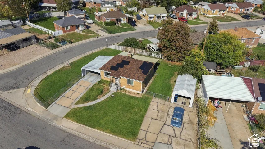 Single-story residence featuring a paved driveway, attached carport, detached carport, and solar panels