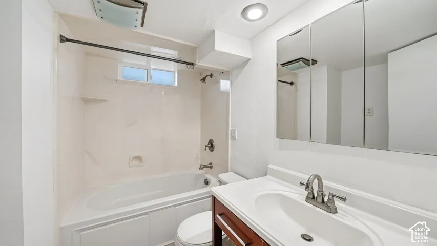 White bathroom vanity with integrated sink, brushed nickel faucet, and a three-panel mirrored medicine cabinet