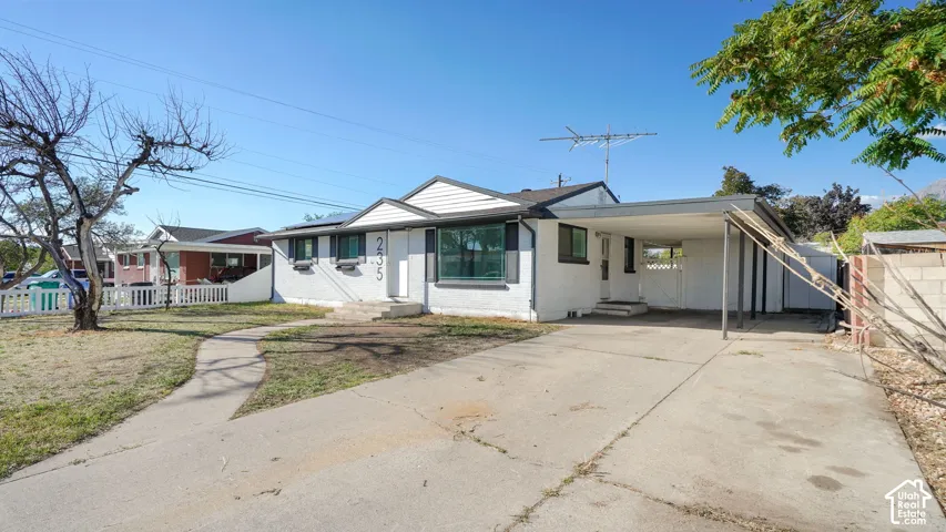 White exterior with dark trim and a covered carport