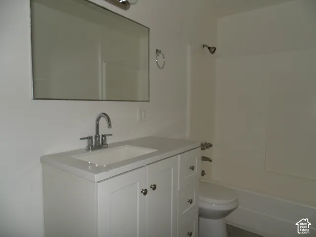 White vanity with an integrated sink, polished chrome faucet, and rectangular wall mirror