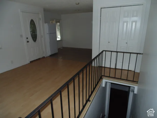 Wood-finish flooring throughout, white bi-fold closet doors, and black metal stair railing