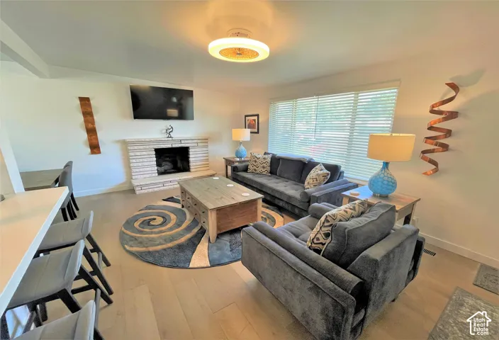 Living area featuring a stone-clad fireplace and wood-finish flooring