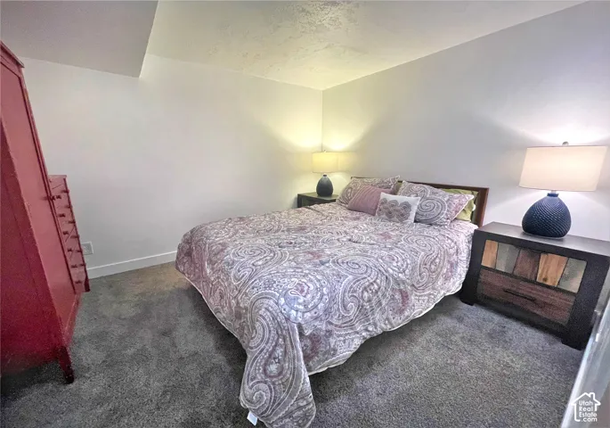 Wall-to-wall carpeting with white walls and a sloped ceiling