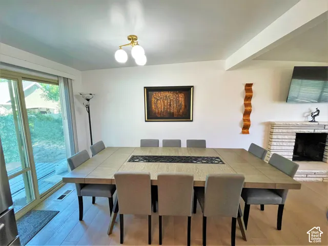 Expansive room featuring wood-finish flooring, a stone fireplace, and a large sliding glass door