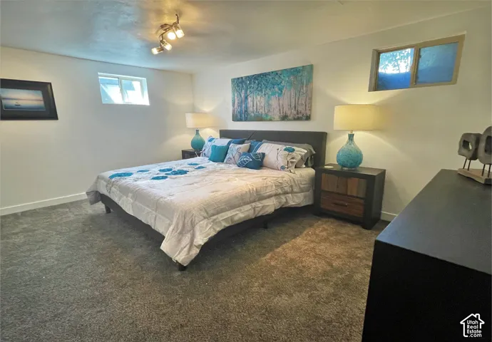Recessed windows, wall-mounted track lighting, and soft carpet flooring