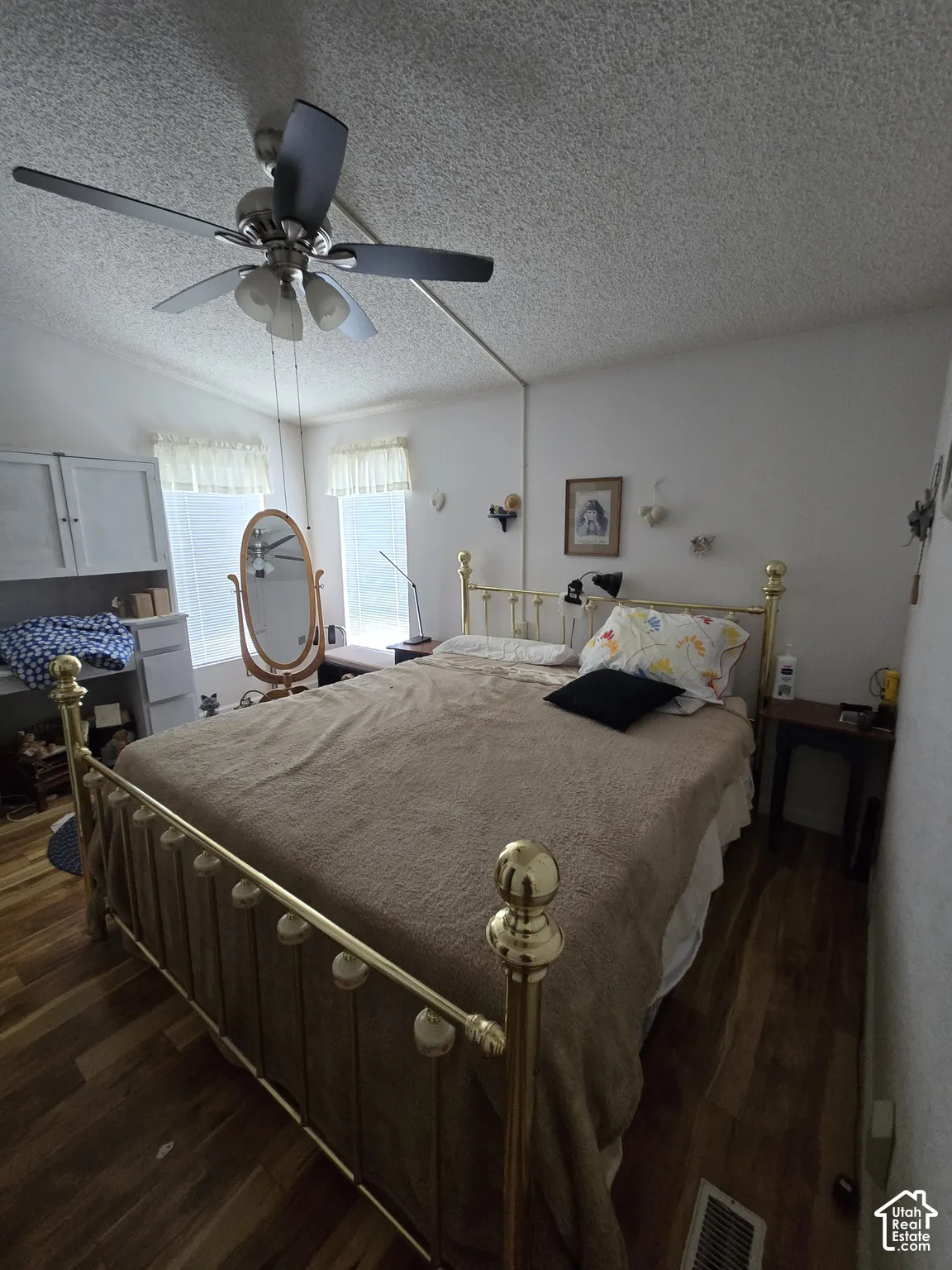 Wood-finish flooring with a ceiling fan light fixture and dual windows