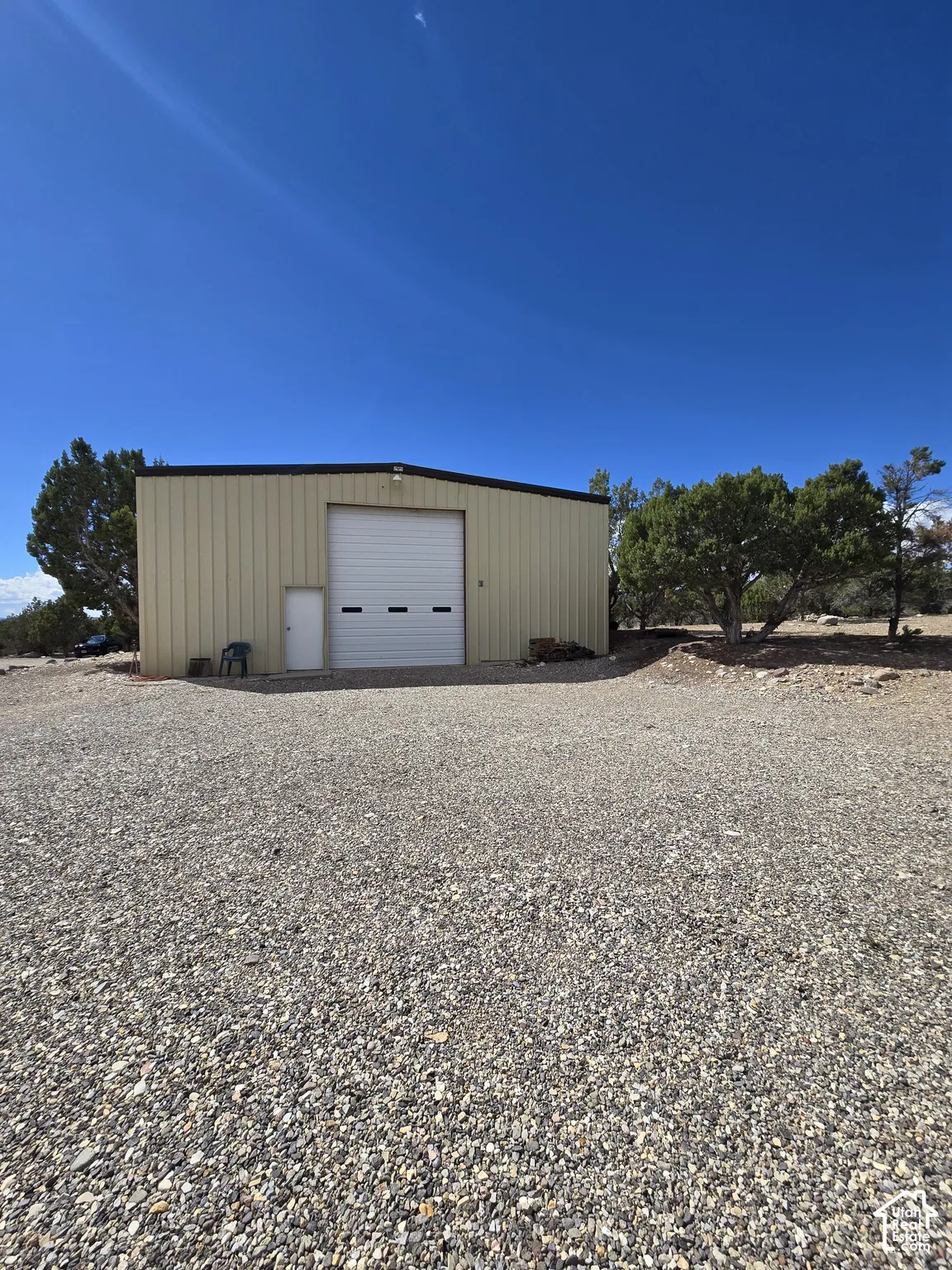 Metal-sided building featuring a large roll-up door and a separate entry door
