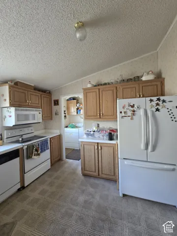 Kitchen featuring wood-finish cabinetry, white countertops, and white appliances