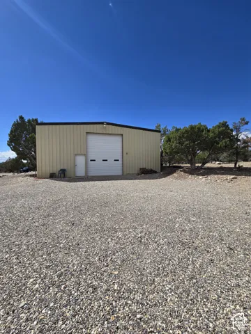 Metal-sided building featuring a large roll-up door and a separate entry door