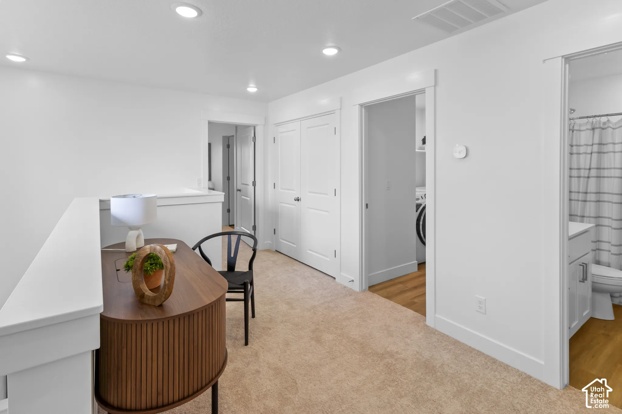Carpeted landing with recessed lighting, white walls, and white trim