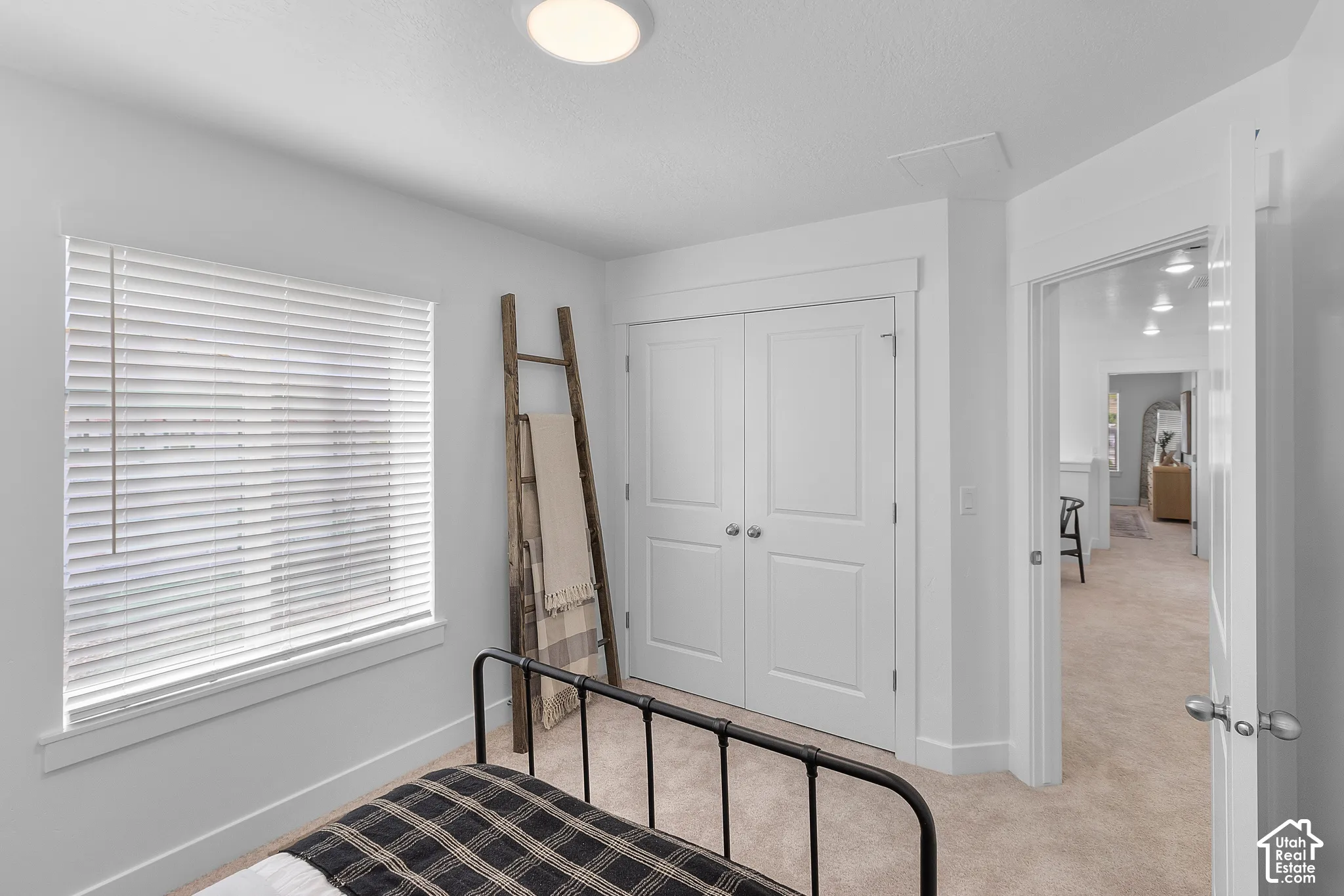 Wall-to-wall carpeting with a double-door closet and white trim