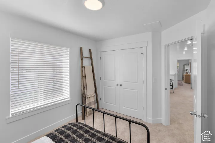 Wall-to-wall carpeting with a double-door closet and white trim