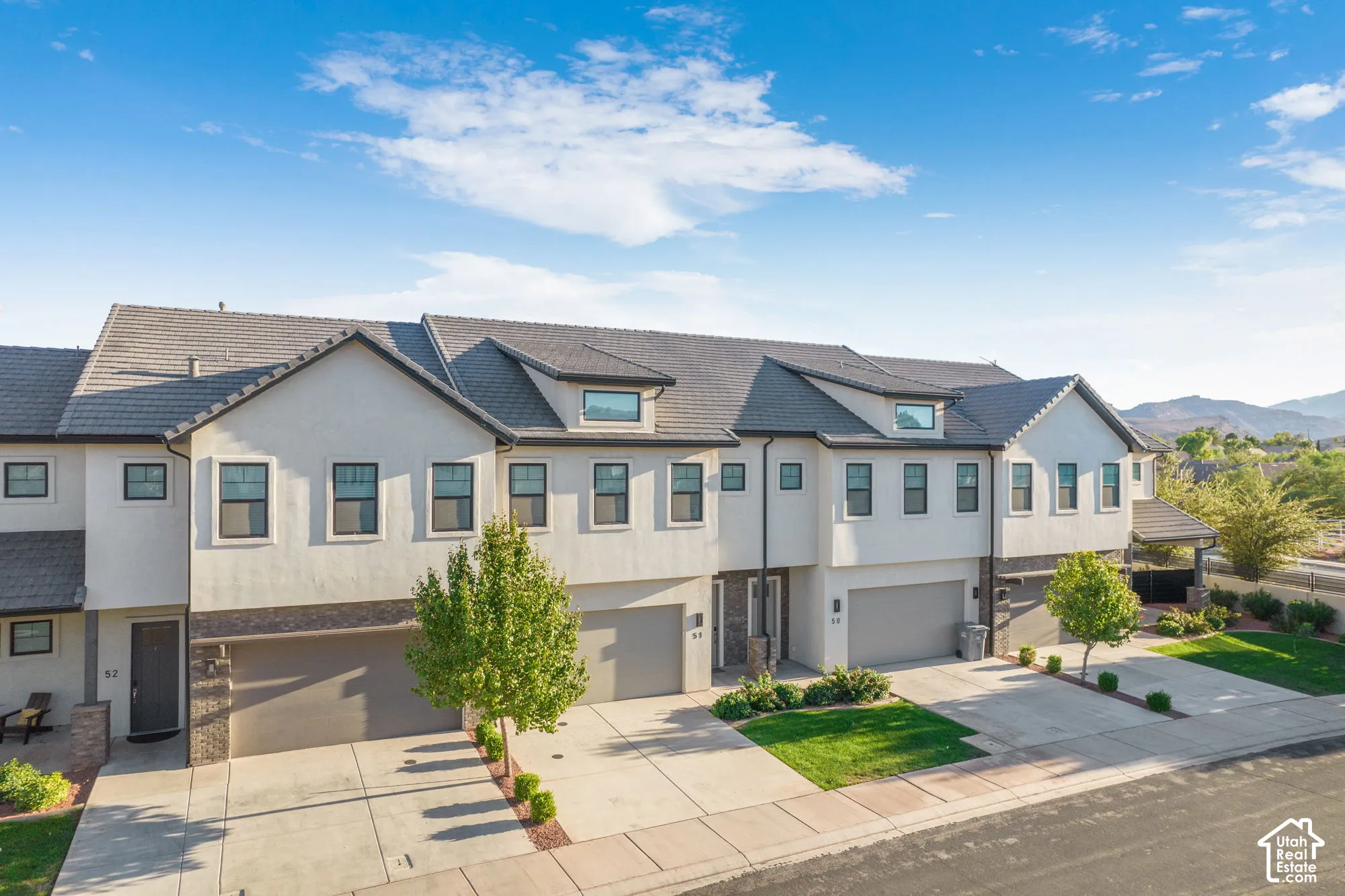 Multi-story stucco exterior with gabled roof lines and dormer windows