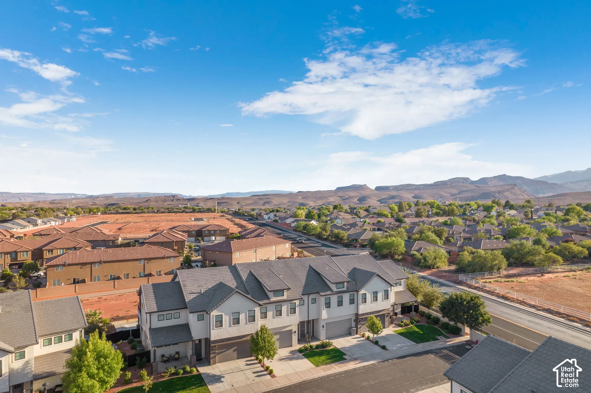 Townhome community featuring multi-story residences, attached garages, and landscaped front yards
