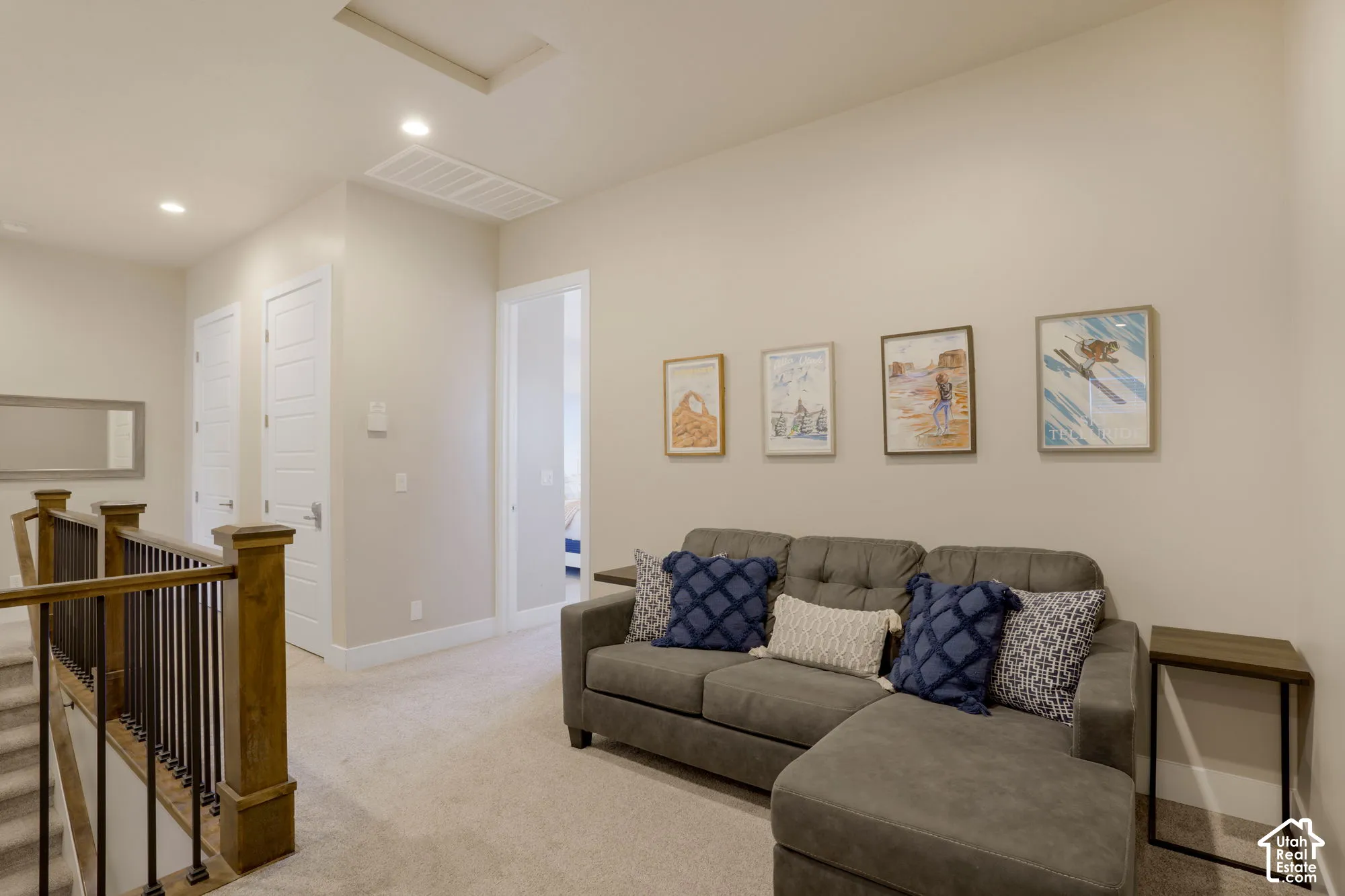 Carpeted landing area featuring a wood and wrought iron railing, recessed lighting, and crisp white trim