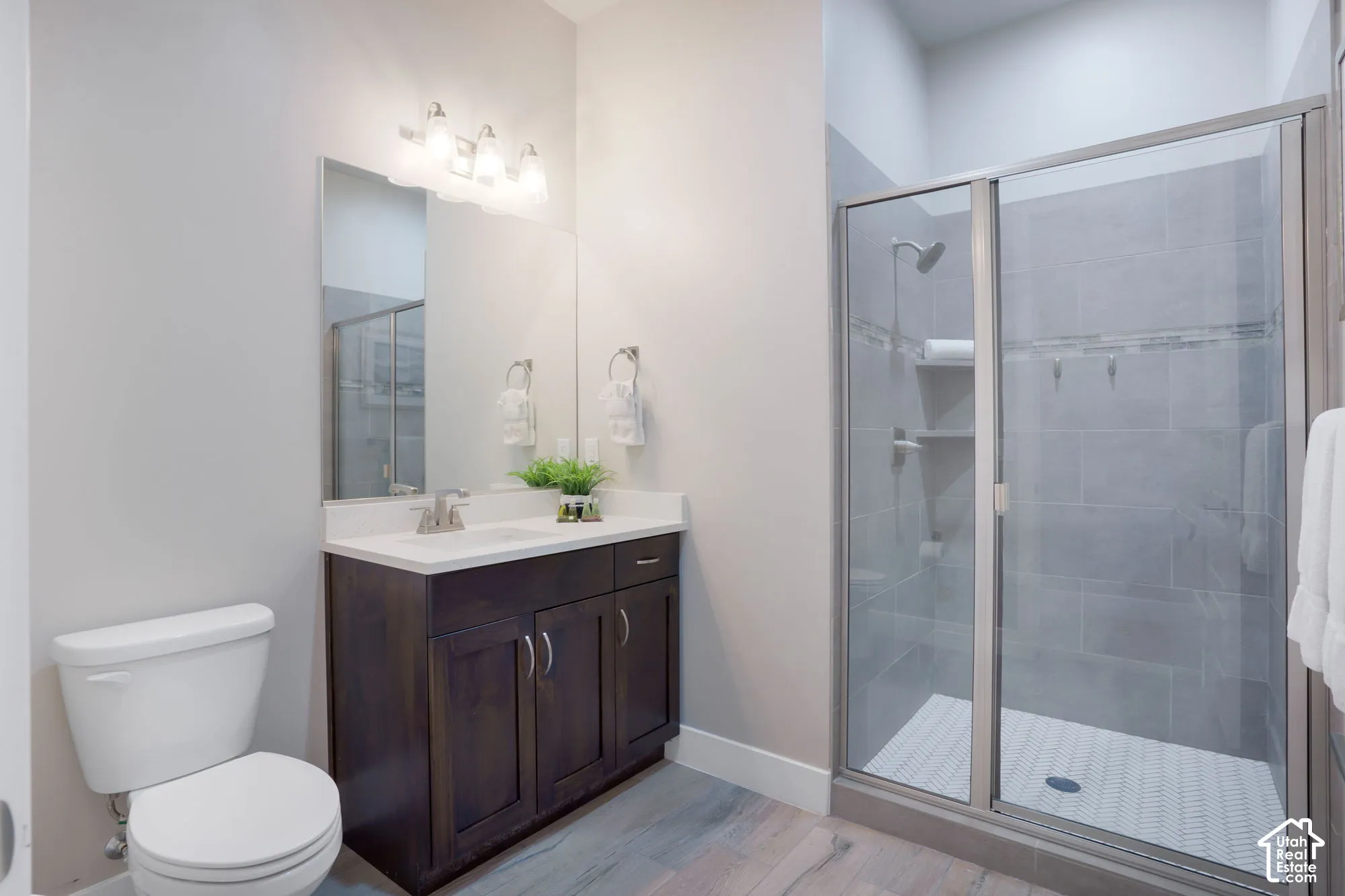 Walk-in shower with clear glass enclosure and tiled walls