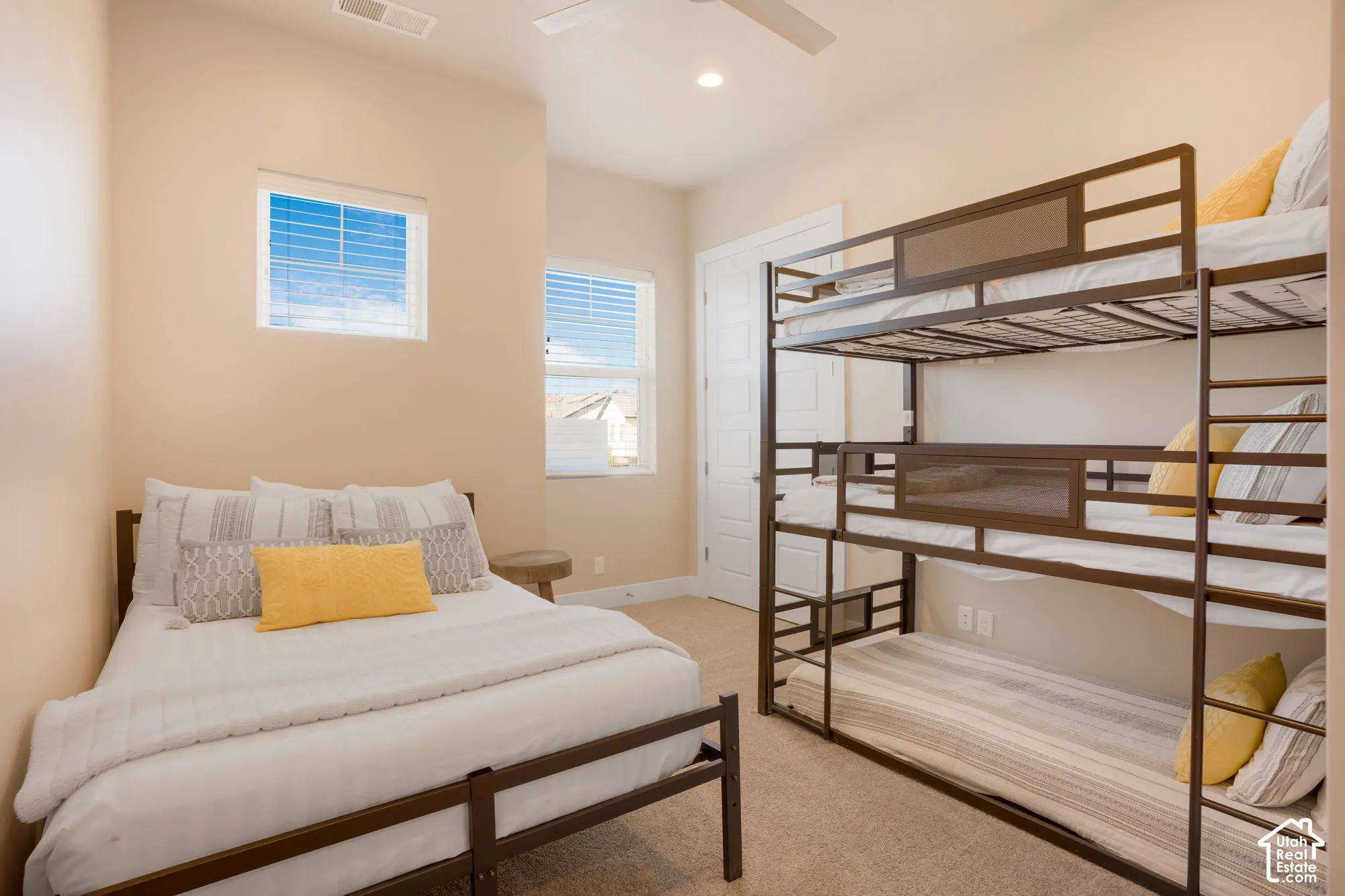 Recessed ceiling lighting, ceiling fan, two windows with blinds, built-in closet with panel door, and carpet flooring
