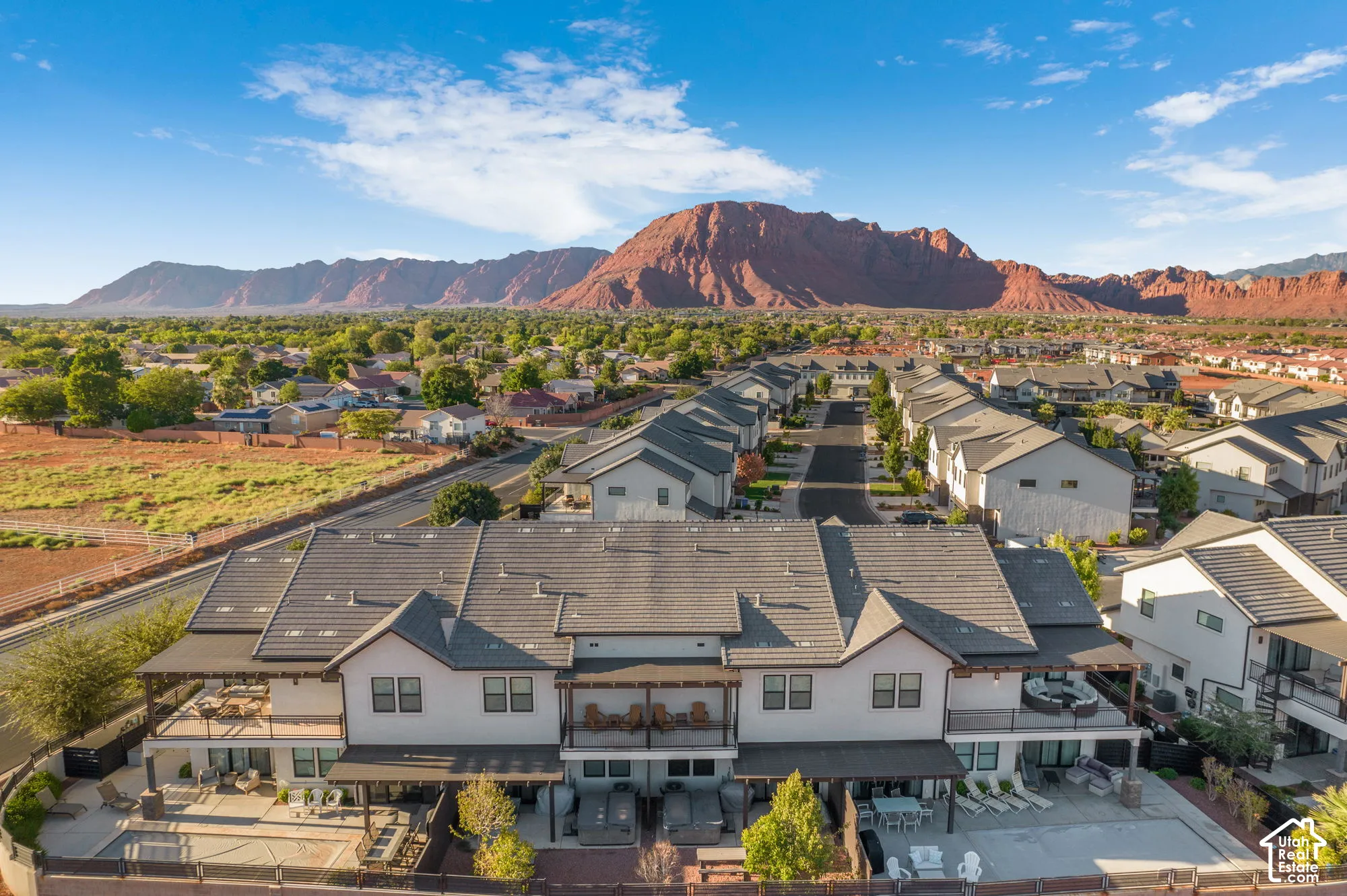Multi-level townhome featuring covered outdoor patios, upper-level balconies, and a tiled roof