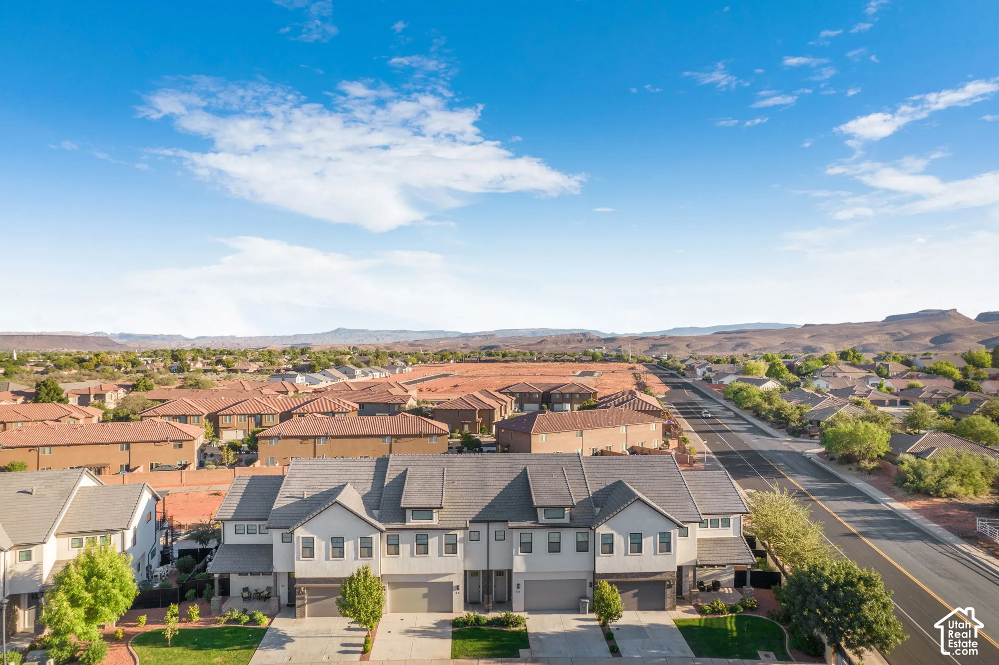 Modern townhome residences featuring multi-car garages, mature landscaping, and mountain vistas