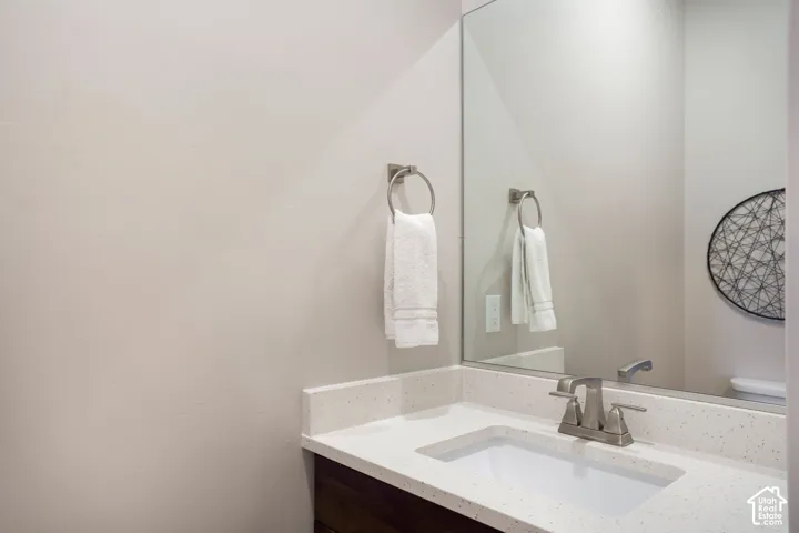 Vanity featuring a white rectangular sink, light-toned countertop, and brushed nickel faucet