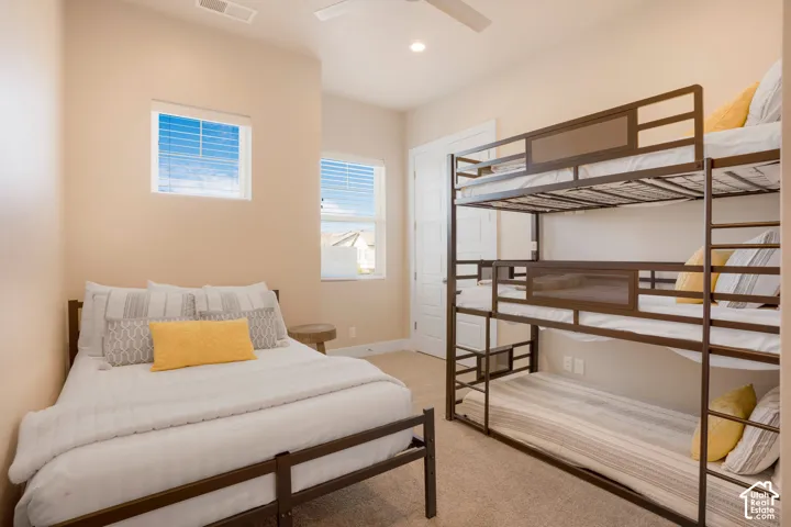 Recessed ceiling lighting, ceiling fan, two windows with blinds, built-in closet with panel door, and carpet flooring