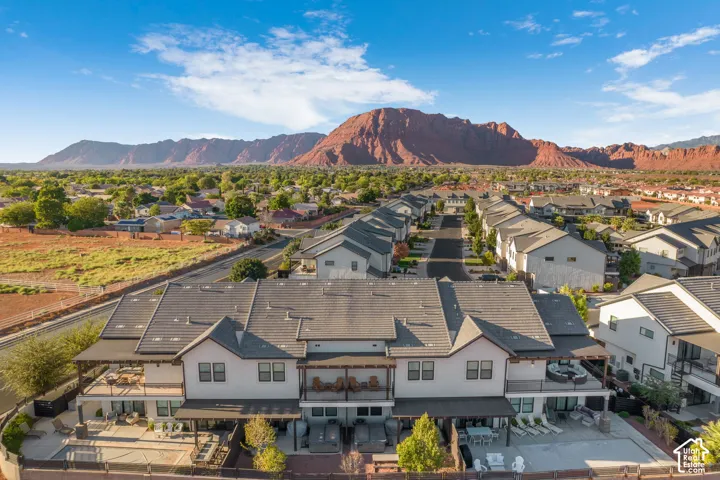 Multi-level townhome featuring covered outdoor patios, upper-level balconies, and a tiled roof