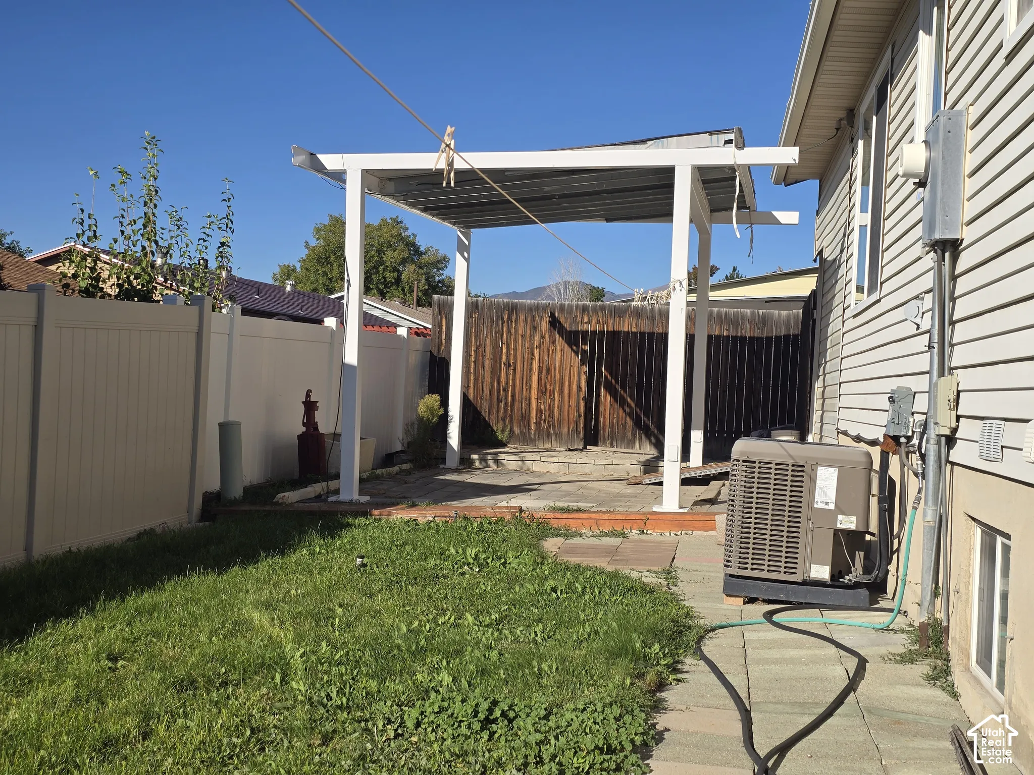 Backyard featuring a covered patio structure, a vinyl privacy fence, and a grass area