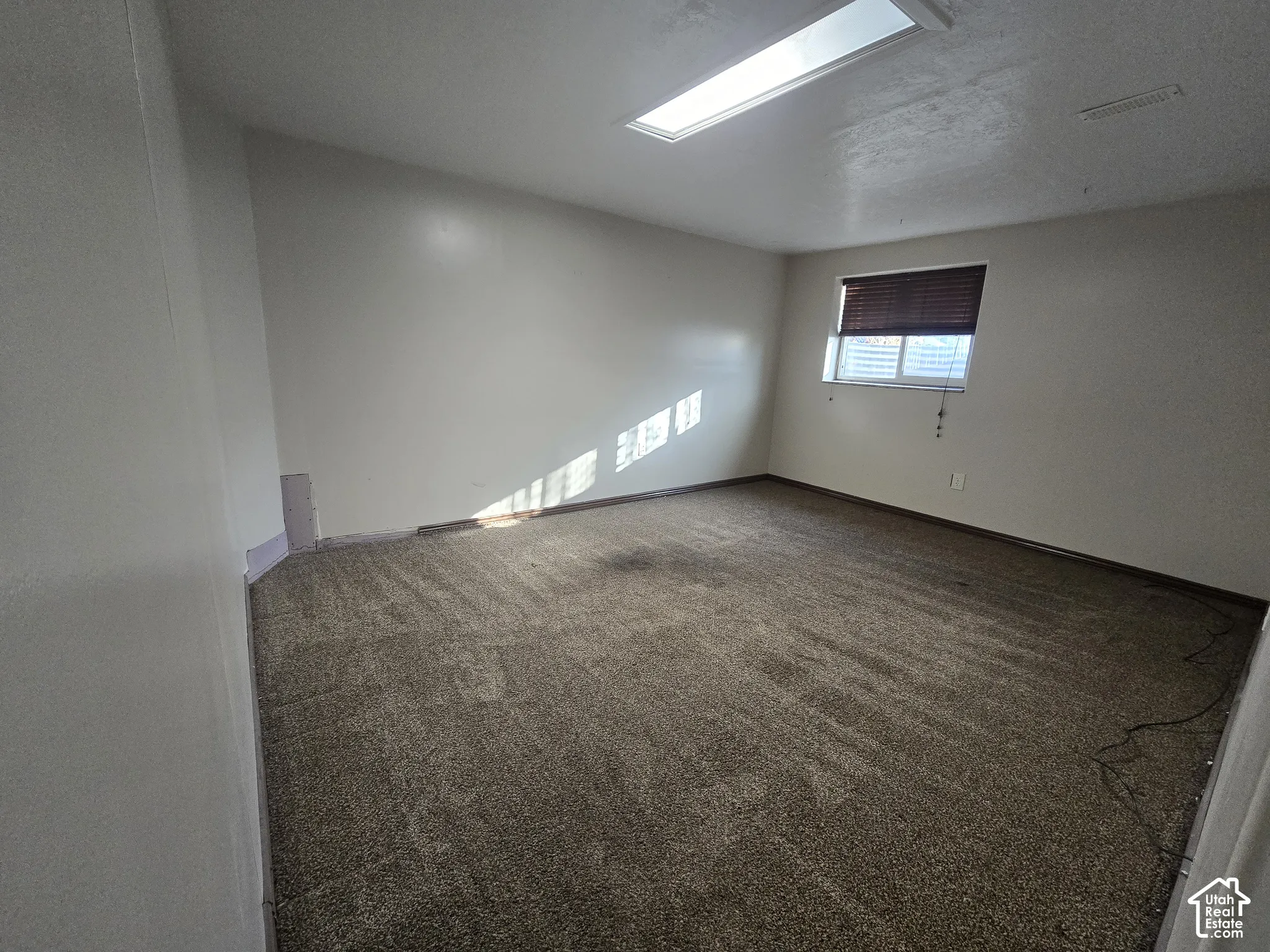 Recessed ceiling light panel, window with horizontal blinds, and neutral wall color