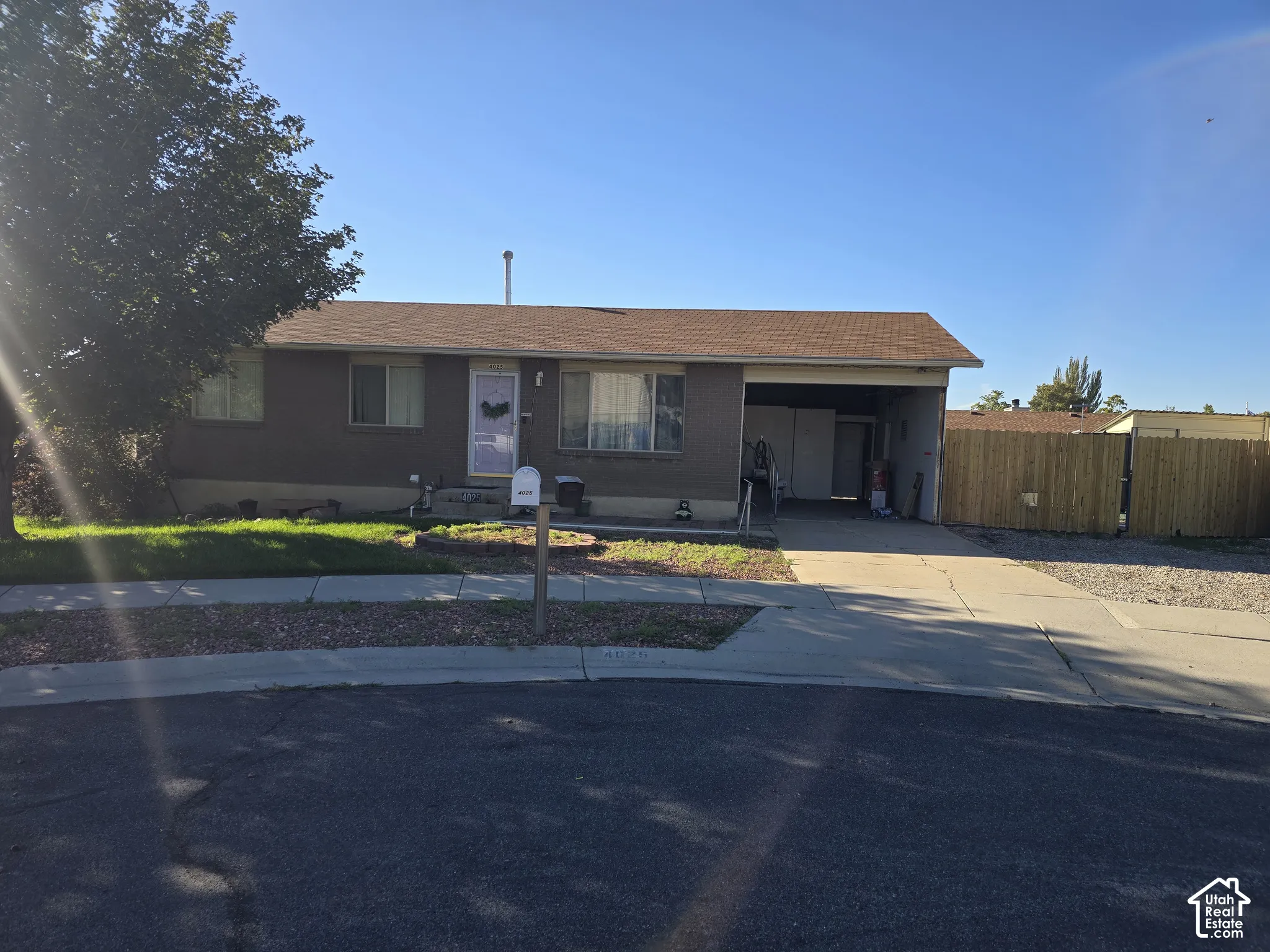 Single-level residence with an attached carport and an asphalt driveway