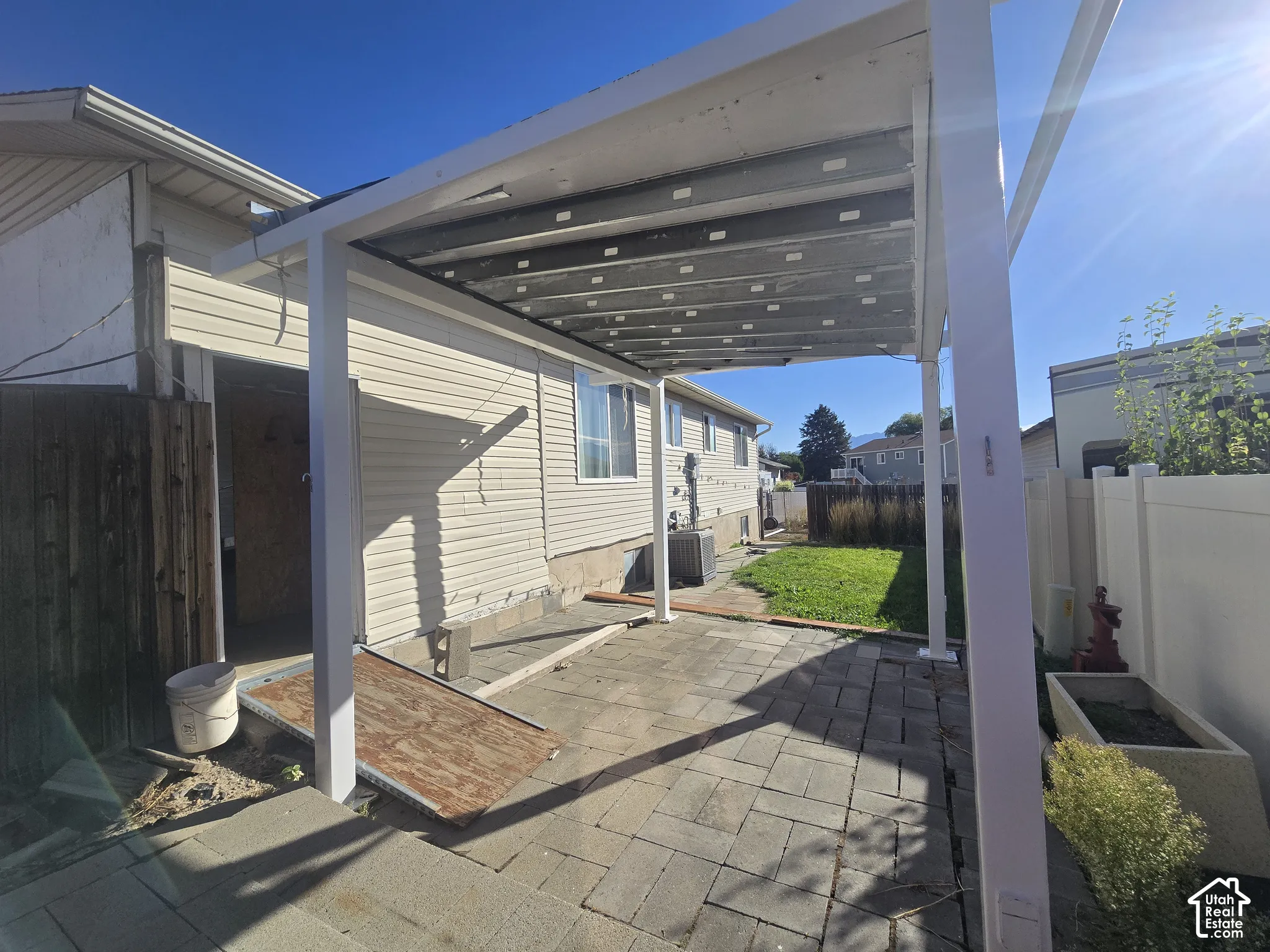 Patio space with paver flooring, shaded by an attached pergola