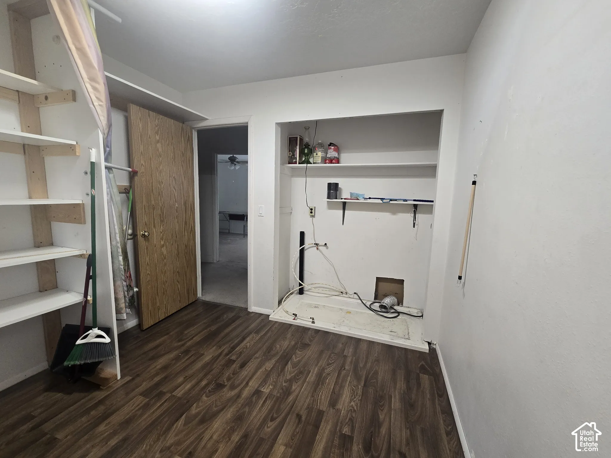 Laundry area featuring wood-finish flooring and built-in shelving