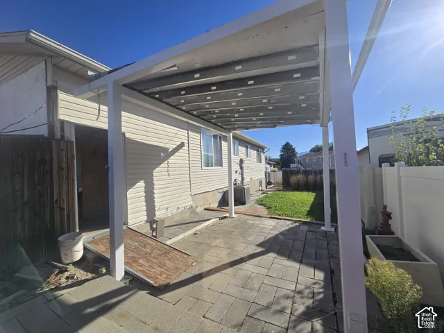 Patio space with paver flooring, shaded by an attached pergola