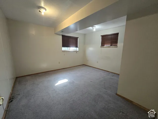 Carpeted room featuring multiple windows with blinds, recessed lighting, and a neutral wall finish