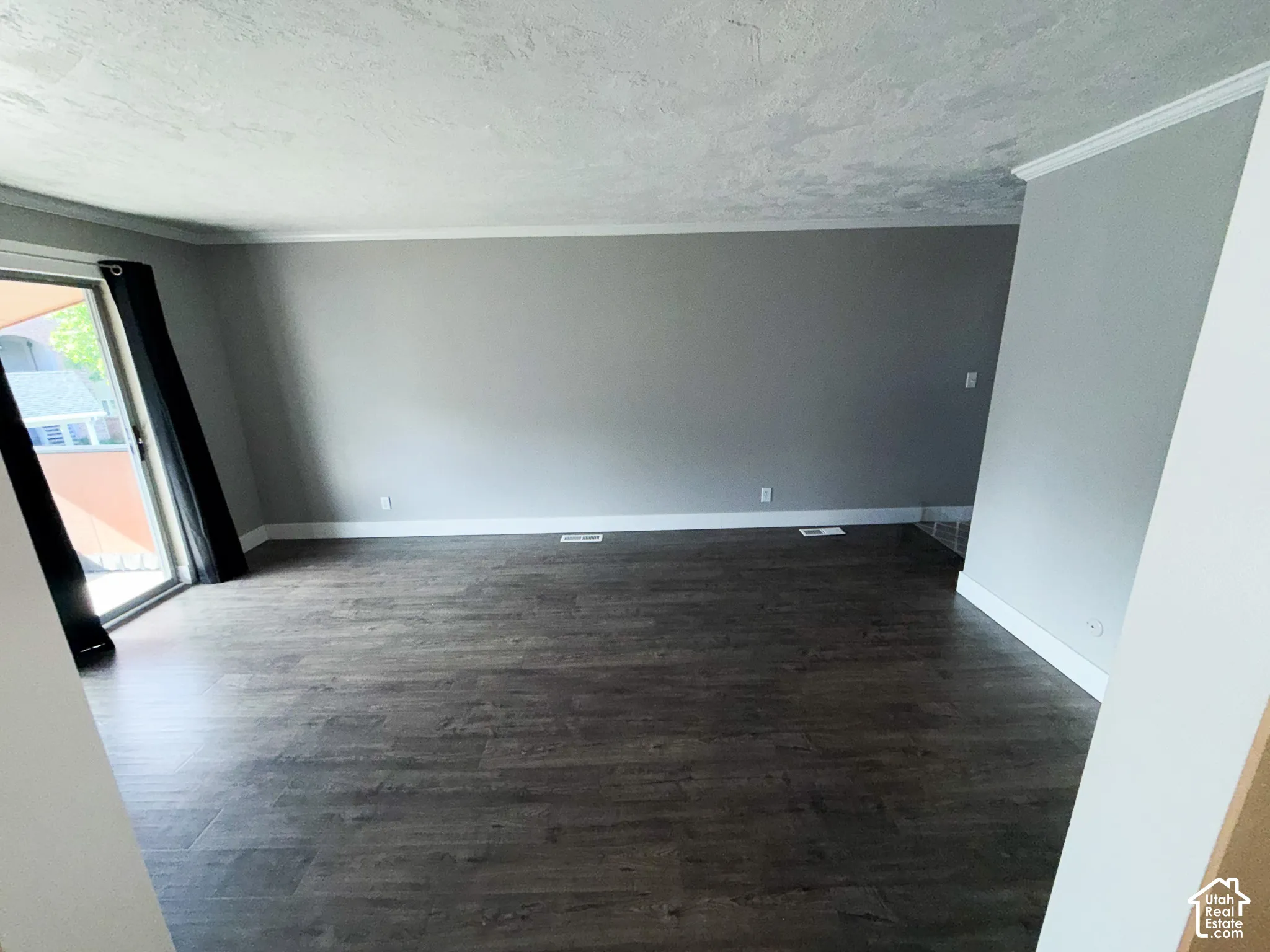 Wood-finish flooring with neutral wall tones and white crown molding