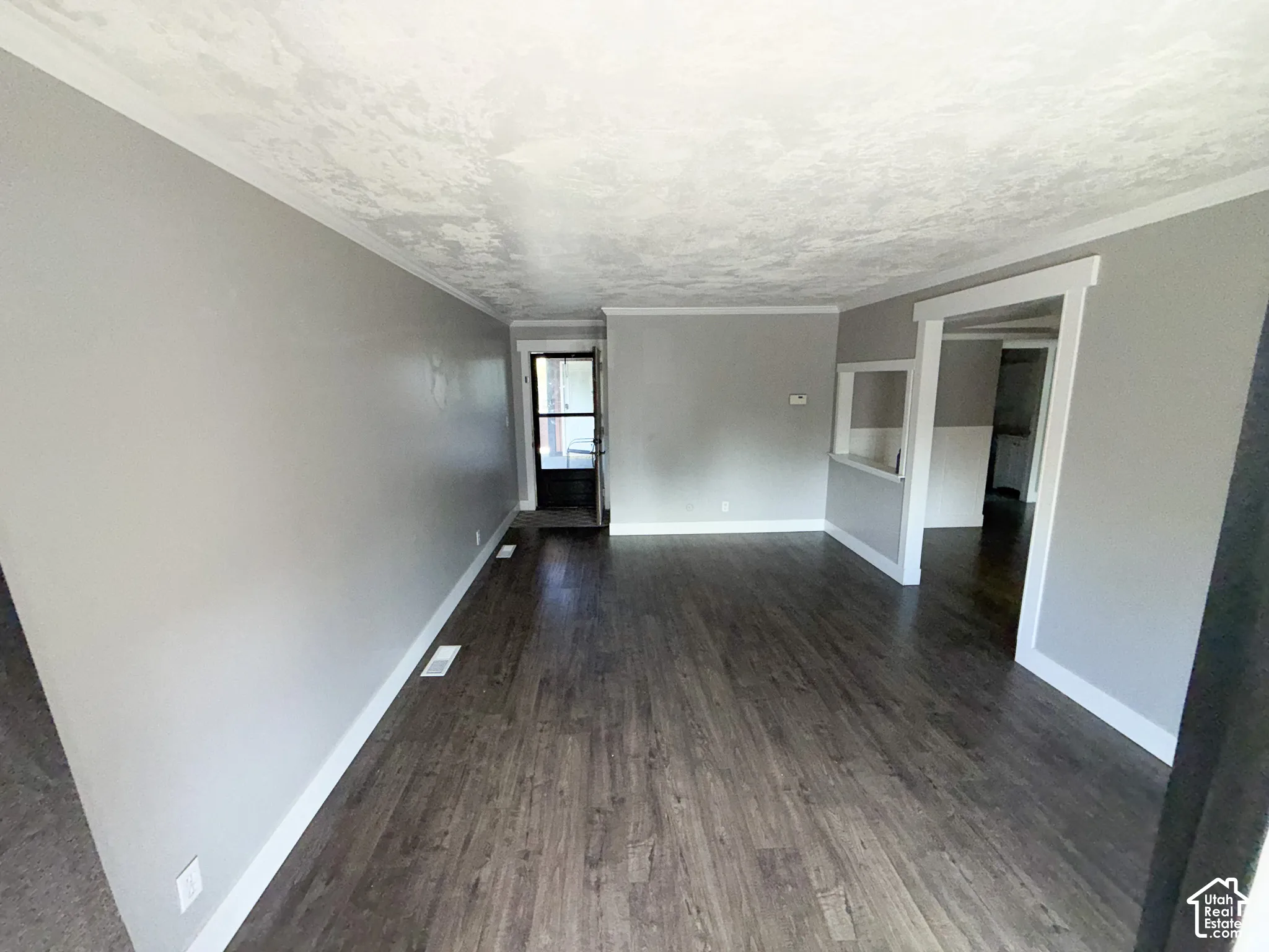 Wood-finish flooring, light gray wall paint, white trim, and a pass-through window