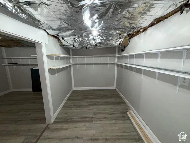 Wood-finish flooring with grey walls and white trim, featuring built-in white shelving