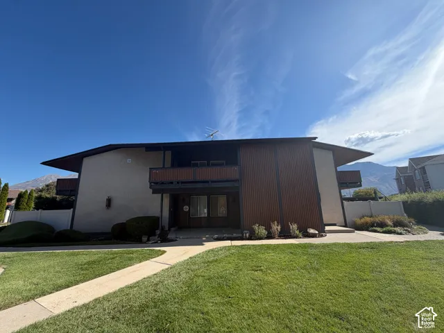 Multi-story exterior with stucco and vertical wood-finish siding