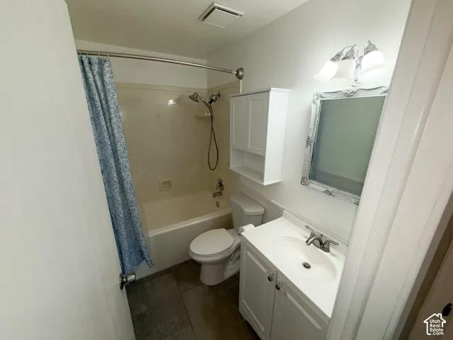 Full bathroom featuring a single vanity, integrated sink, and white cabinetry