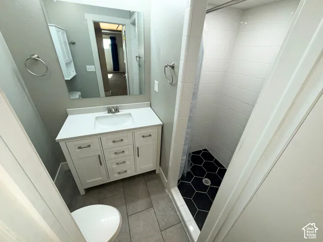 White vanity with a single basin sink and brushed nickel faucet