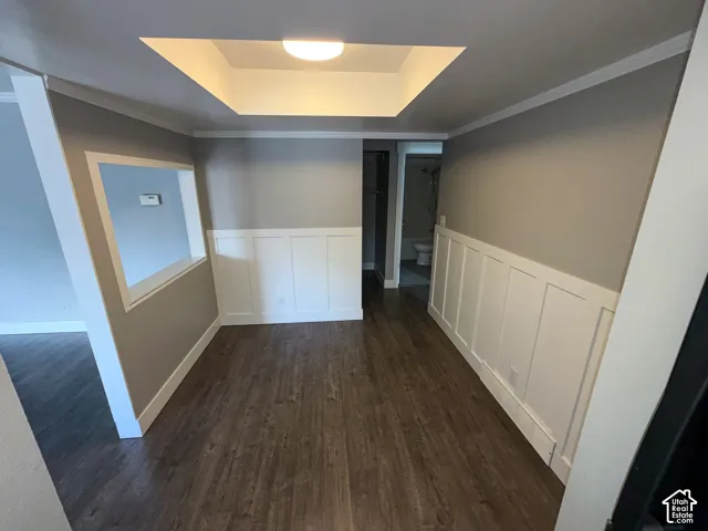Wood-finish flooring, recessed ceiling with flush-mount lighting, and white wainscoting