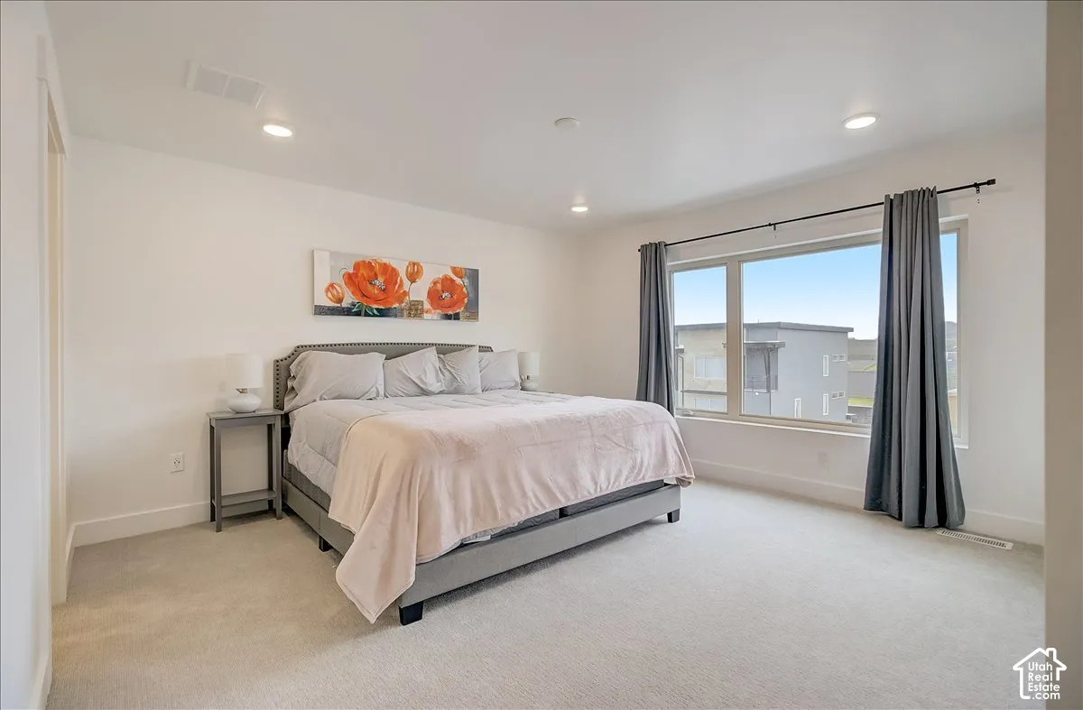 Bright room with carpeted flooring, large window, and recessed lighting